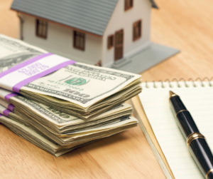 Stack of 100 dollar bills with house representing a home equity loan